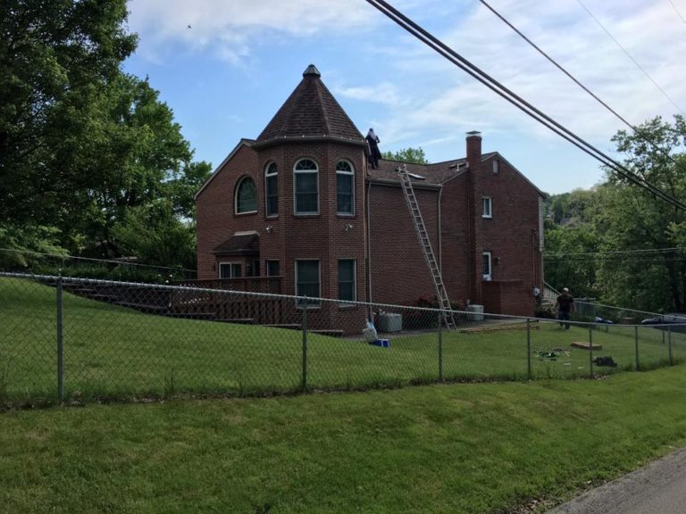 Brick Victorian home with a turret after a roof replacement
