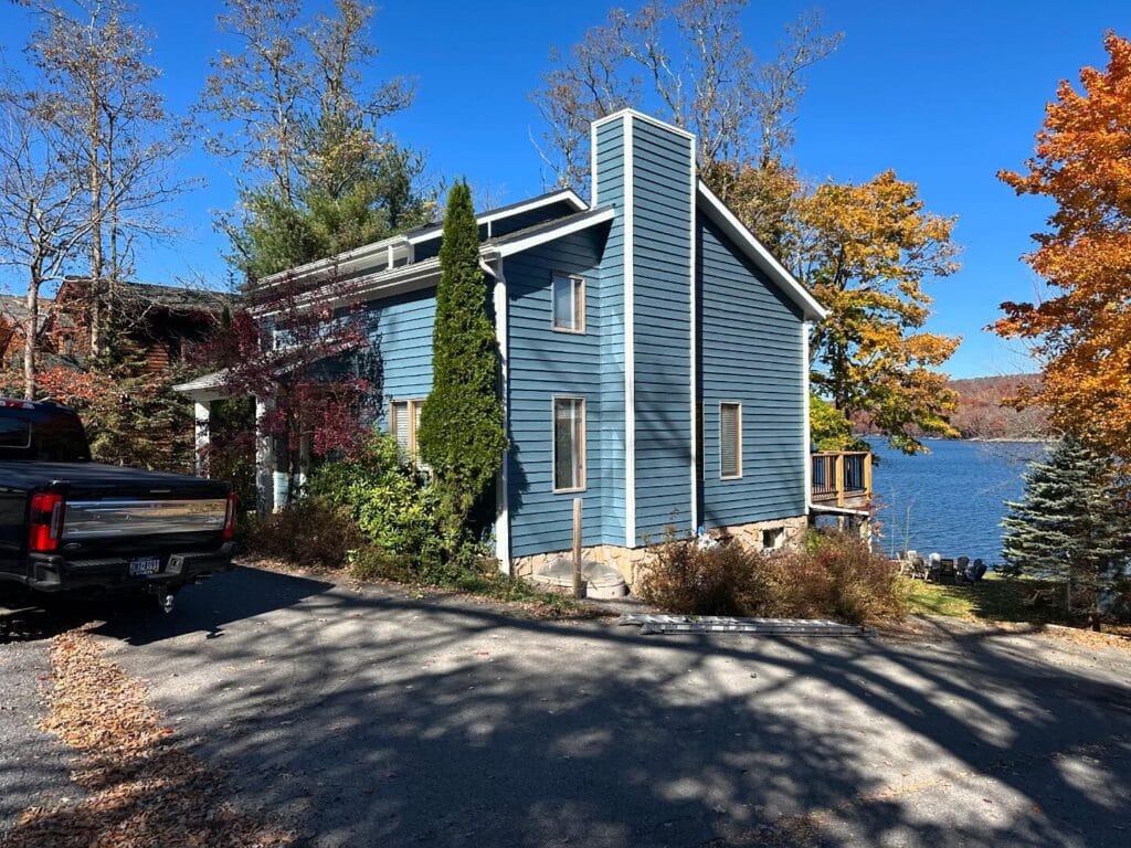 Two-story home with new blue siding and a new roof