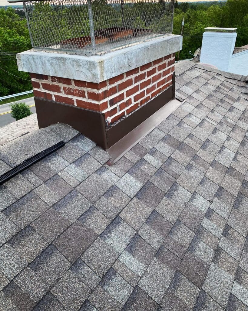 Brick chimney with new flashing on a freshly shingled roof