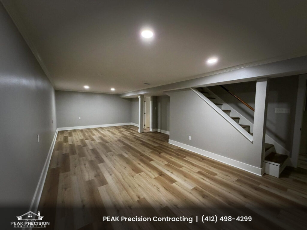 basement-finishing-mcmurray-pa-winter_basement Finished basement with gray walls, white trim, recessed lighting, and wide-plank vinyl flooring by Peak Precision Contracting in Peters Township, PA