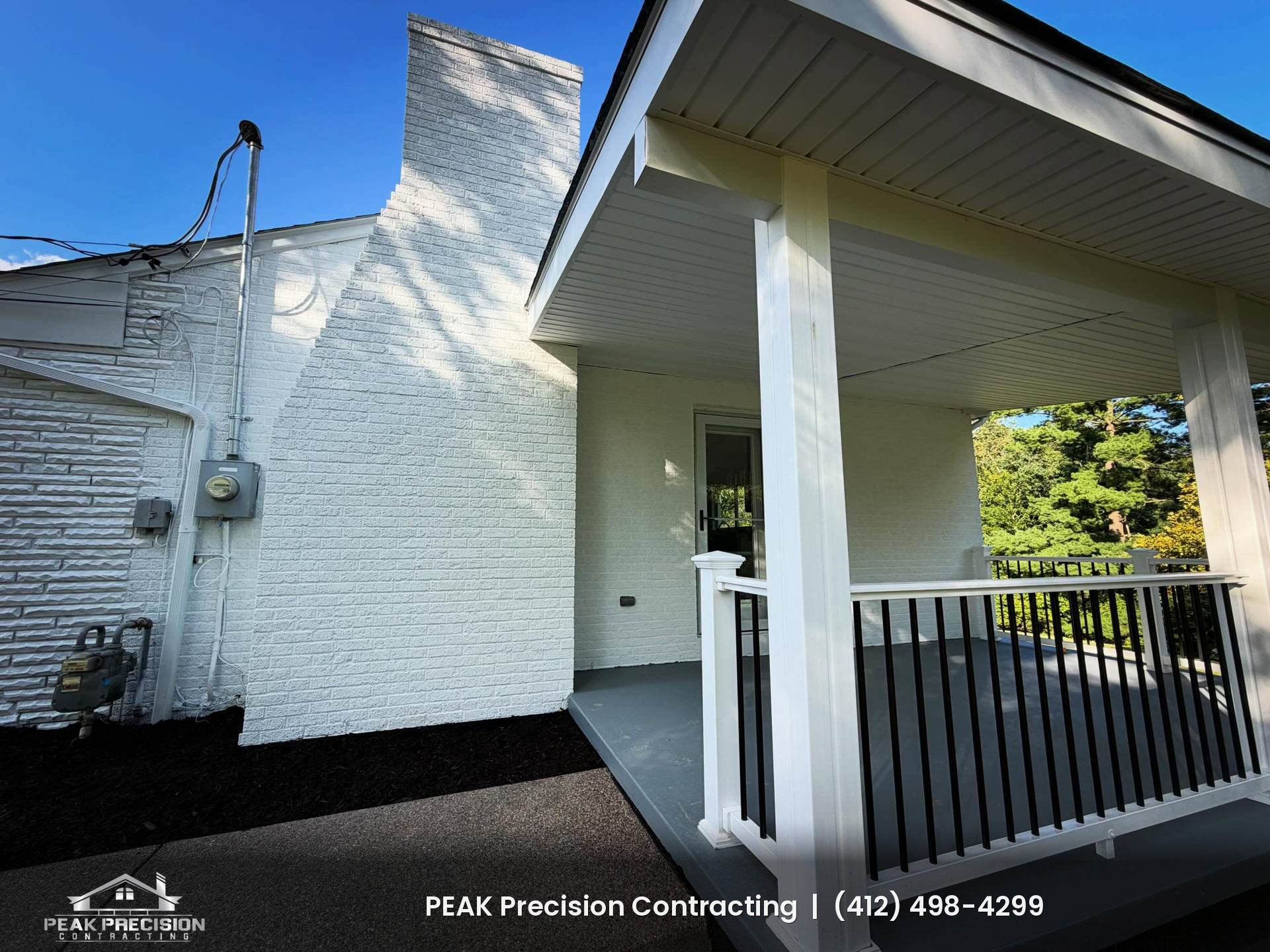 Covered porch with white square columns, white soffit ceiling, gray porch floor, and white railing with black balusters, built by Peak Precision Contracting in Peters Township, PA