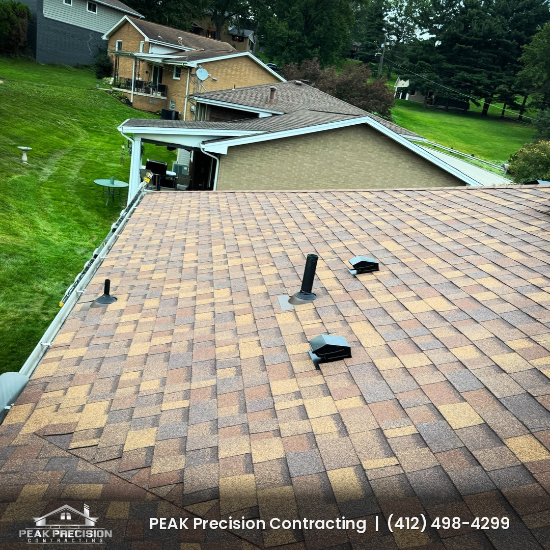 Plumbing vent pipes with new pipe boots and roof vents on a freshly installed shingle roof by Peak Precision Contracting
