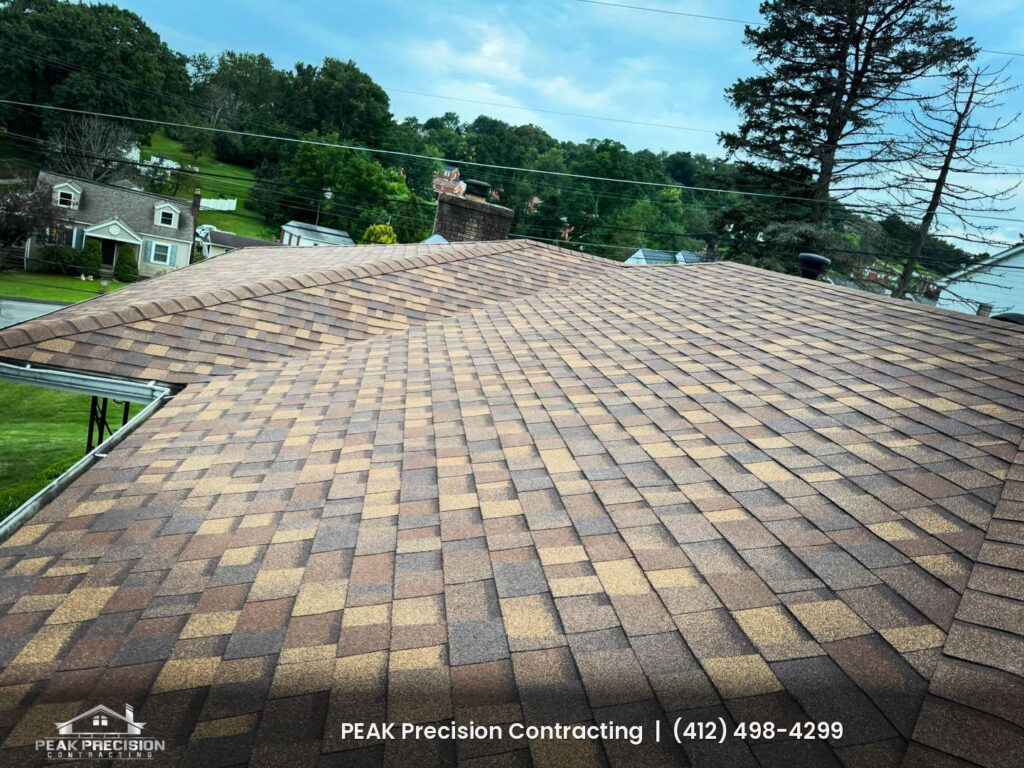 Shingle roof with Owens Corning shingles in Desert Rose, ridge cap, brick chimney, and gutters, installed by Peak Precision Contracting