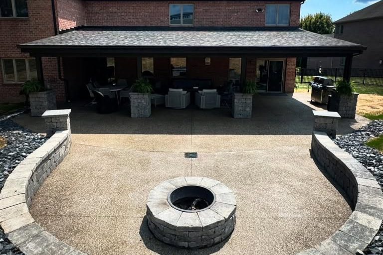 peak-precision-exposed-aggregate-patio-fire-pit-card-1 Exposed aggregate concrete patio with a stone fire pit and curved seat wall by Peak Precision Contracting