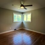 Bedroom with new ceiling fan, fresh paint and hardwood floors after a renovation by Peak Precision Contracting in Peters Township, PA