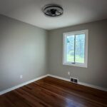 Freshly painted bedroom with new trim and hardwood floors, renovated by Peak Precision Contracting in Peters Township, PA