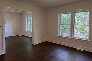 Renovated living room with fresh paint, new windows and vinyl plank flooring by Peak Precision Contracting