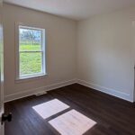 Renovated bedroom with fresh paint and vinyl plank flooring by Peak Precision Contracting