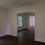 Freshly painted room with white walls and trim opening to the next room, by Peak Precision Contracting