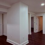 Freshly painted open lower level with recessed lights and wrapped column by Peak Precision Contracting