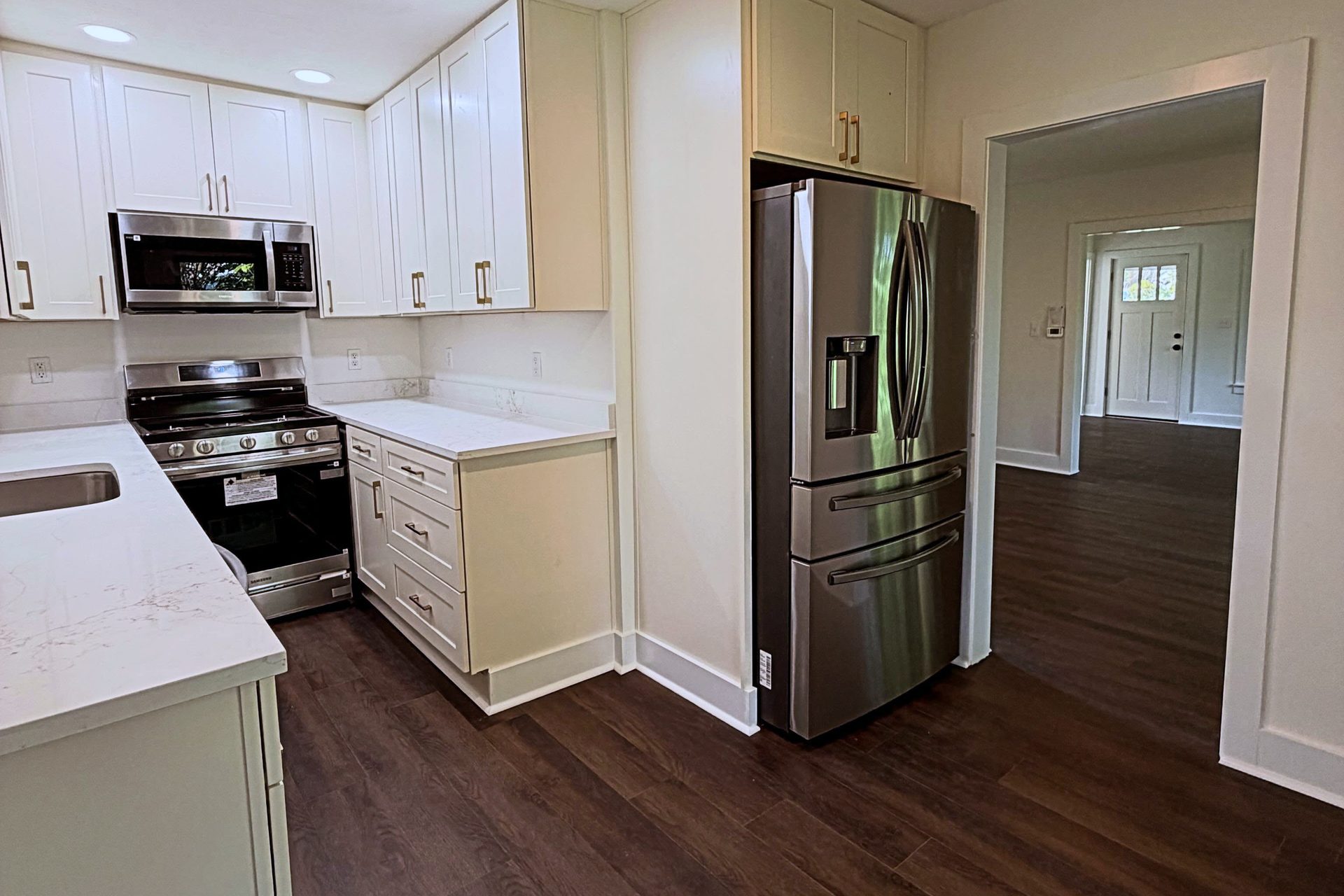 Kitchen remodel by Peak Precision Contracting with white shaker cabinets, quartz countertops and stainless steel appliances