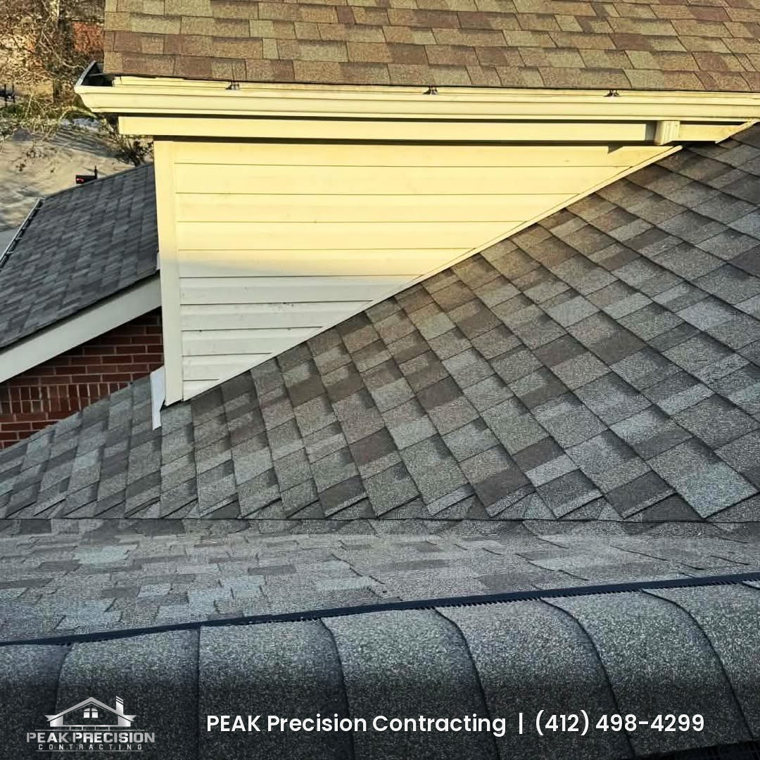 Roof-to-sidewall junction and ridge cap on a shingle roof completed by Peak Precision Contracting