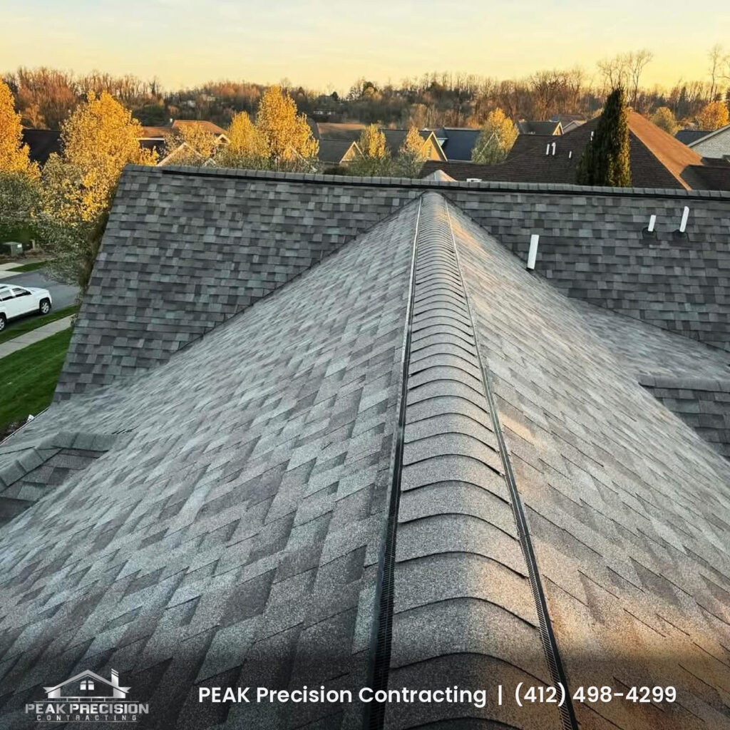 Asphalt shingle roof with a ridge vent and clean ridge cap lines at sunset, completed by Peak Precision Contracting
